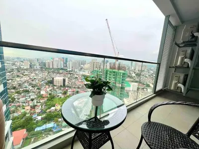 a glass table with a vase on it on a balcony at Cozy 2 Bedrooms in BGC with Balcony Bathtub 600Mbps in Manila