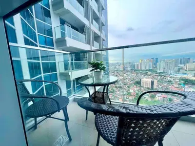 a balcony with a table and chairs on a building at Cozy 2 Bedrooms in BGC with Balcony Bathtub 600Mbps in Manila
