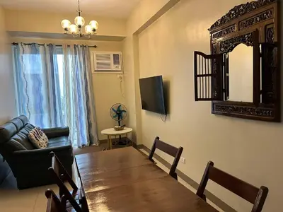 a living room with a table and a couch and a mirror at The Verdin at Maple Grove in Cavite