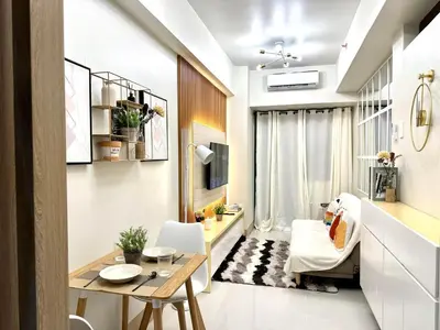 a small living room with a table and a chair at SMDC Shore 3 Residences - One Bedroom Unit in Manila