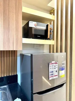 a kitchen with a stainless steel refrigerator with a microwave at SMDC Shore 3 Residences - One Bedroom Unit in Manila