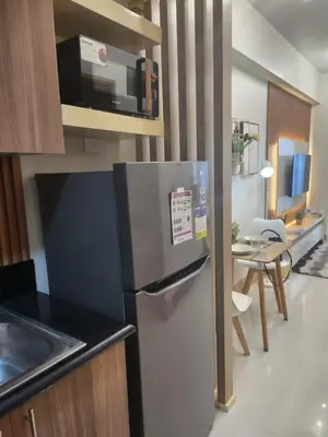 a kitchen with a stainless steel refrigerator and a table at SMDC Shore 3 Residences - One Bedroom Unit in Manila