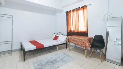 a bedroom with a bed and a chair and a window at MCP Transient near NAIA in Manila