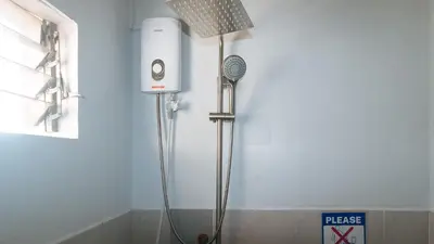 a shower in a bathroom with a blow dryer at MCP Transient near NAIA in Manila