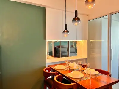 a dining room with a wooden table and chairs at Manila Philippines, Azure Urban Resort Staycation by Leroche near Ninoy Aquino International Airport in Manila