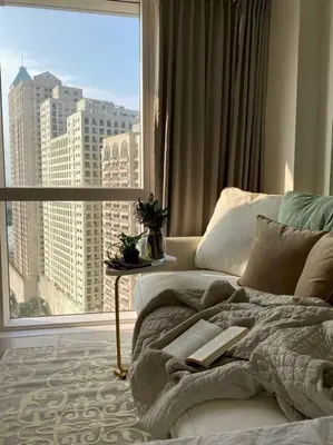 a bed with a book on it in a room with a window at -CONDO- Petite Residential Stay in Manila