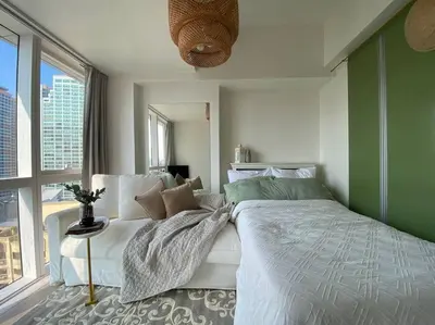a bedroom with a large bed and a large window at -CONDO- Petite Residential Stay in Manila