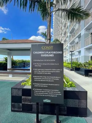 a sign for the coast childrens playgrounds at a building at Cozy Penthouse 2BR Suite w Balcony - Amazing Manila Bay View and City Skyline near MOA in Manila