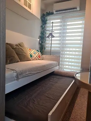a bed in a room with a window at Cozy Penthouse 2BR Suite w Balcony - Amazing Manila Bay View and City Skyline near MOA in Manila