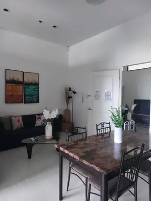 a living room with a wooden table and chairs at Homestead in Manila