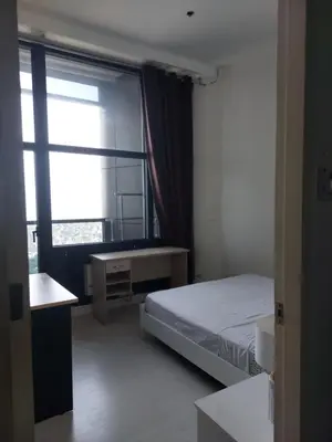 a bedroom with a bed and a large window at Homestead in Manila