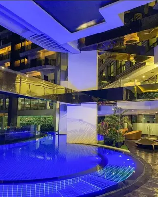 a large building with a swimming pool at night at Homestead in Manila