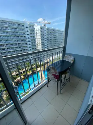 a balcony with a table and a view of a building at Shell Residence Moa - Anne in Manila