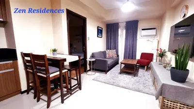 a living room with a table and chairs in a room at Bliss by Zen Residences at The Radiance Manila Bay in Manila