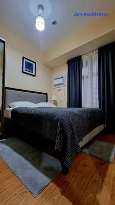 a bedroom with a large bed with a black blanket at Bliss by Zen Residences at The Radiance Manila Bay in Manila