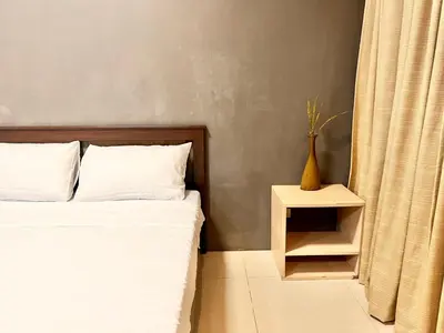a bedroom with a bed and a vase on a side table at Elegant Condo Hotel across NAIA Airport Terminal 3 Newport City in Manila