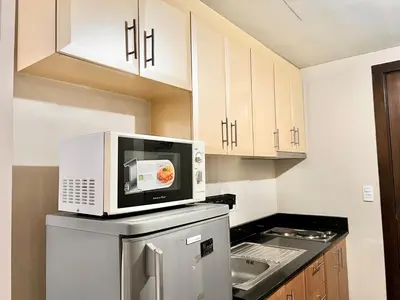 a kitchen with a microwave on top of a refrigerator at Elegant Condo Hotel across NAIA Airport Terminal 3 Newport City in Manila