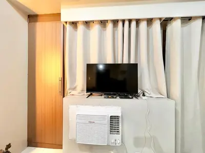 a television on top of a refrigerator in a room at Elegant Condo Hotel across NAIA Airport Terminal 3 Newport City in Manila