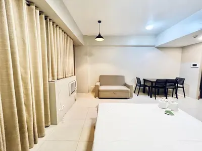 a room with a bed and a table and chairs at Elegant Condo Hotel across NAIA Airport Terminal 3 Newport City in Manila