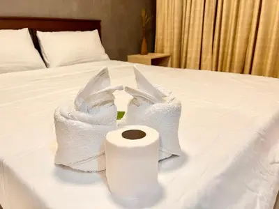 two towels and a roll of toilet paper on a bed at Elegant Condo Hotel across NAIA Airport Terminal 3 Newport City in Manila
