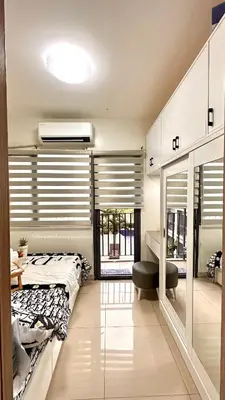 a bedroom with a bed and a desk and a window at Cozy Condo near Mall of Asia in Manila