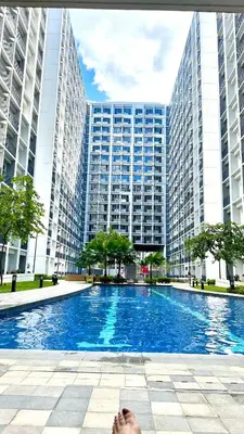 a person laying on the ground in front of a large building at Cozy Condo near Mall of Asia in Manila