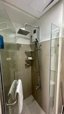 a shower in a bathroom with a glass door at Cozy Condo near Mall of Asia in Manila