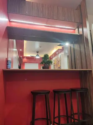 a bar with three bar stools in front of a mirror at Cozy Studio Unit near Manila Airport With Swimming Pool, Full Kitchen 7A in Manila