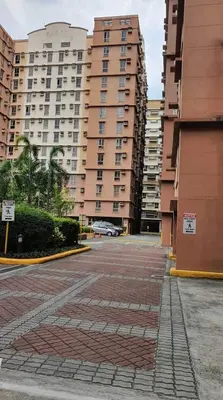 a parking lot in front of some tall buildings at Cozy Studio Unit near Manila Airport With Swimming Pool, Full Kitchen 7A in Manila
