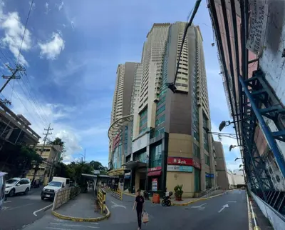 a woman walking down a city street with tall buildings at Modern Bayview Condo in 8 Adriatico in Manila
