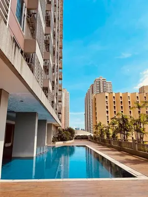 a swimming pool in the middle of a building with tall buildings at Modern Bayview Condo in 8 Adriatico in Manila