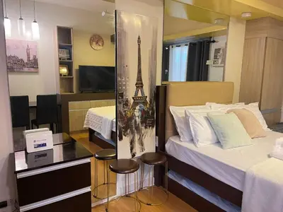 a hotel room with two beds and a television at Modern Bayview Condo in 8 Adriatico in Manila
