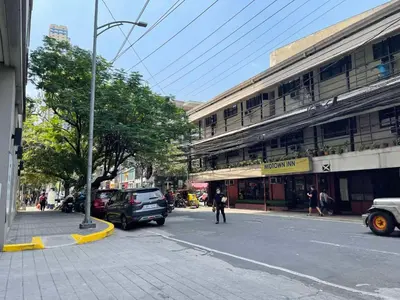 a city street with cars parked in front of a building at Modern Bayview Condo in 8 Adriatico in Manila
