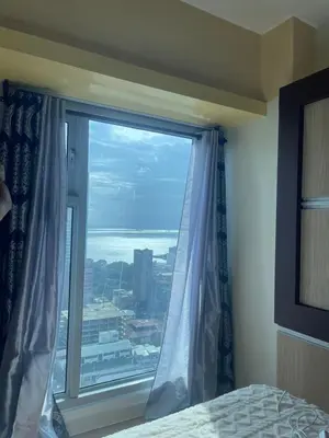 a bedroom with a window with a view of the ocean at Modern Bayview Condo in 8 Adriatico in Manila