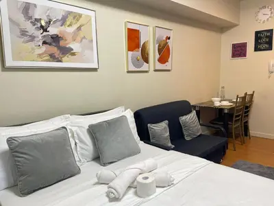 a bedroom with a bed and a table and chairs at 8 Adriatico Staycation in Manila