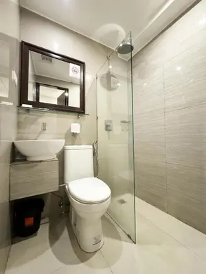a bathroom with a toilet and a sink and a mirror at Nest Fort BGC in Manila