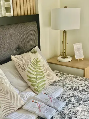 a bed with two gifts on it with a lamp at Homestay by ViJiTa 2bedroom condo in Manila
