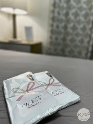 a white napkin with red ribbon on a bed at Homestay by ViJiTa 2bedroom condo in Manila