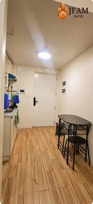 a room with a table and a kitchen with a door at JFam Suites, C3-3N Studio, Up To 4 Pax in Biñan