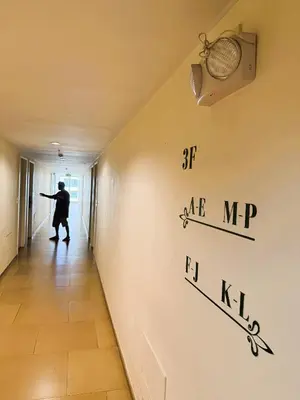 a man walking down a hallway with a sign on the wall at JFam Suites, C3-3N Studio, Up To 4 Pax in Biñan