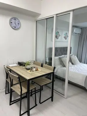 a dining room with a table and chairs and a bed at Azure Urban Resort Residences in Manila