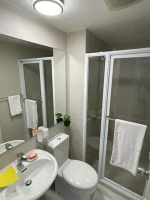 a bathroom with a toilet and a sink and a shower at Azure Urban Resort Residences in Manila