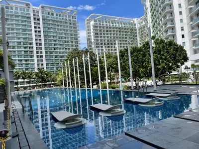 a swimming pool with a fountain in front of buildings at Azure Urban Resort Residences in Manila