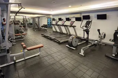 a gym with treadmills and machines in a room at Chill Apartment in Makati in Manila