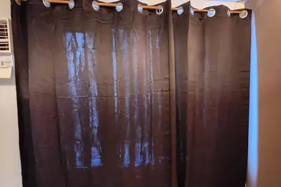 a brown shower curtain in a room with a window at Chill Apartment in Makati in Manila
