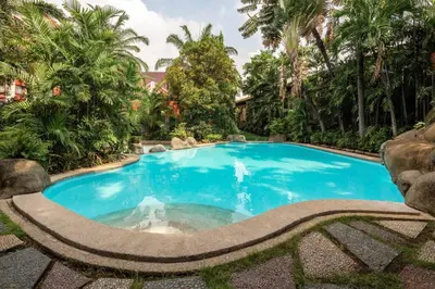 a large blue swimming pool with trees in the background at Brand New Studio in Pasig with Free Pool Access in Manila