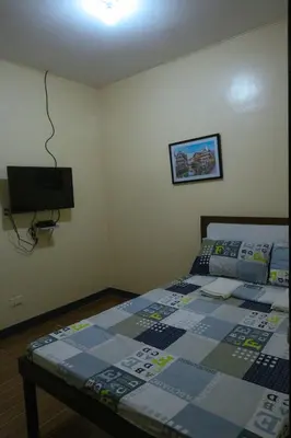 a bedroom with a bed and a flat screen tv at Villa Elsie Resort and Hotel in General Trias