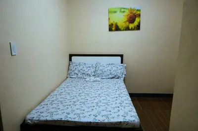 a bed in a small room with a picture on the wall at Villa Elsie Resort and Hotel in General Trias