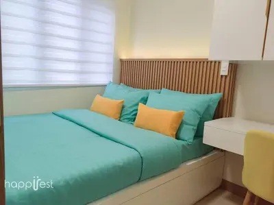 a bed with blue and orange pillows and a window at Happirest at S Residences w/Balcony, Mall of Asia in Manila