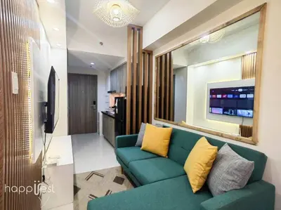 a living room with a green couch and a television at Happirest at S Residences w/Balcony, Mall of Asia in Manila